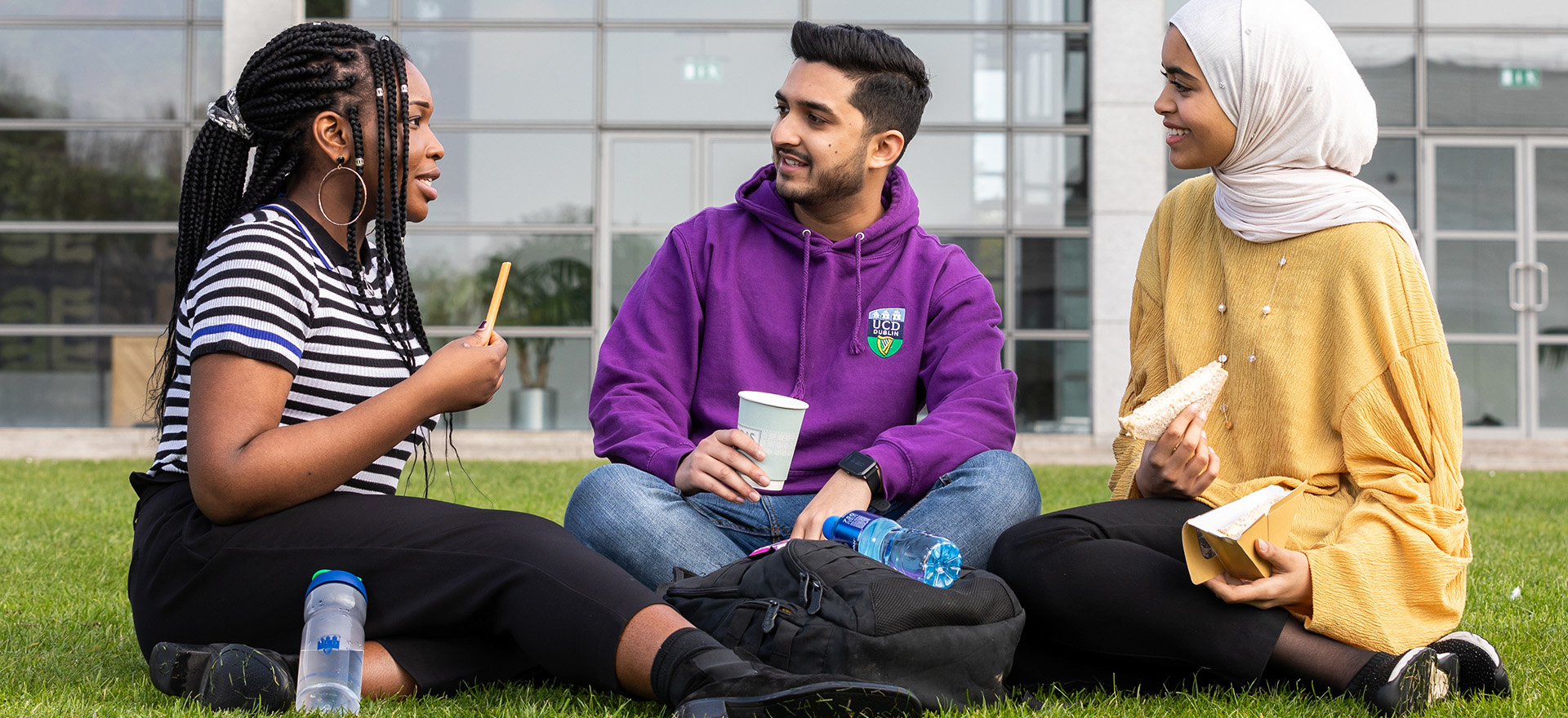 three international students eating lunch outside on UCD Campus